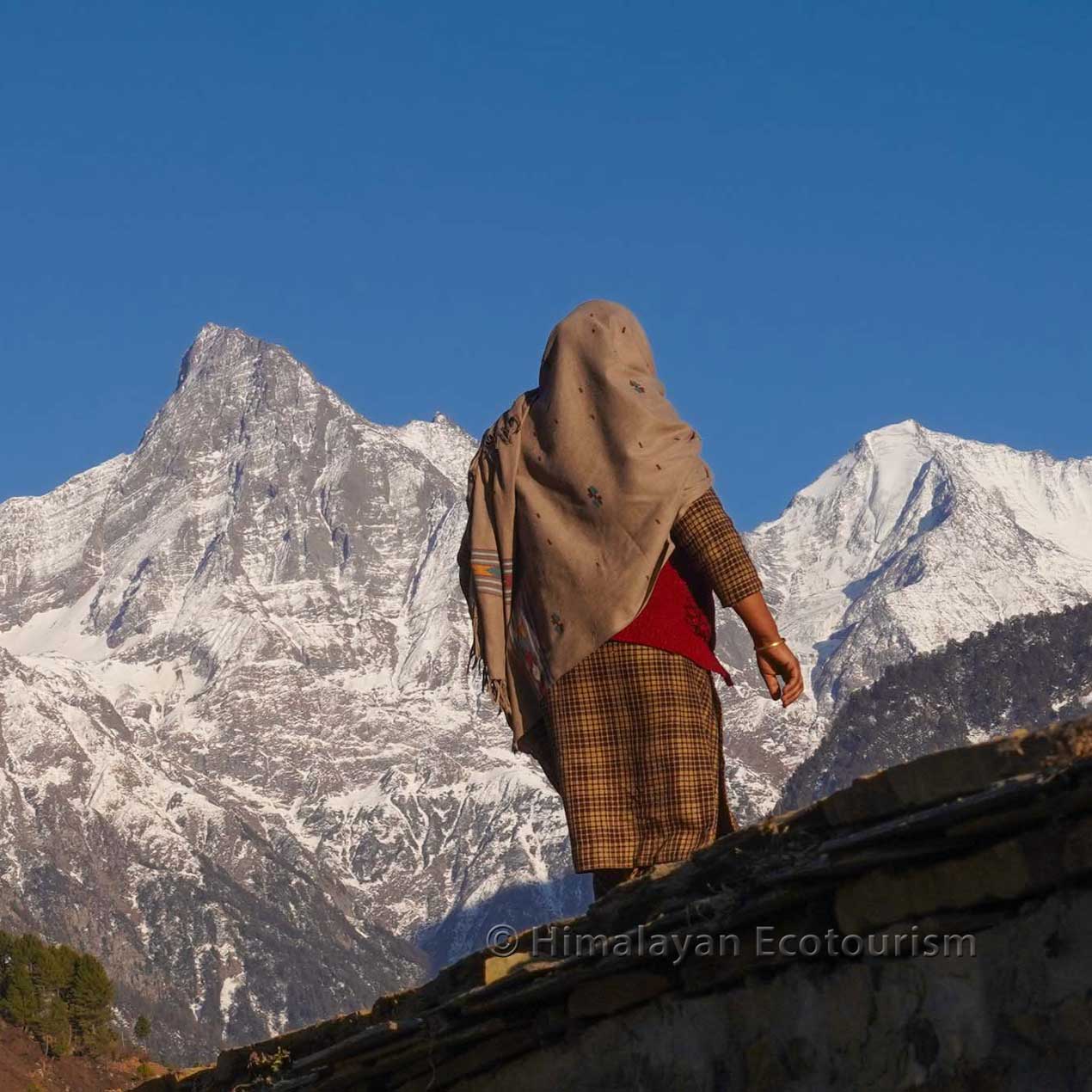 A woman fromnt of snow-capped mountains in the Churah valley