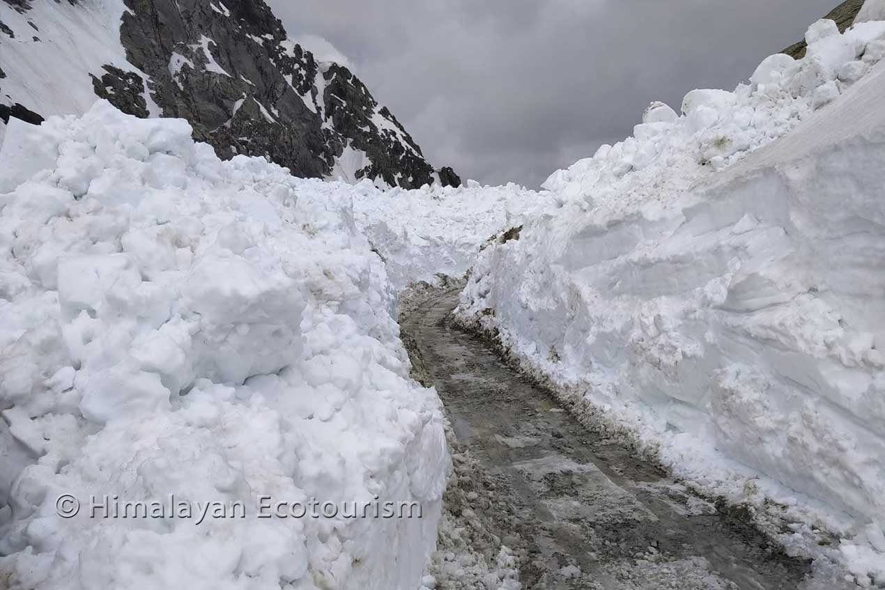 Crossing the Sach pass through high walls of snow