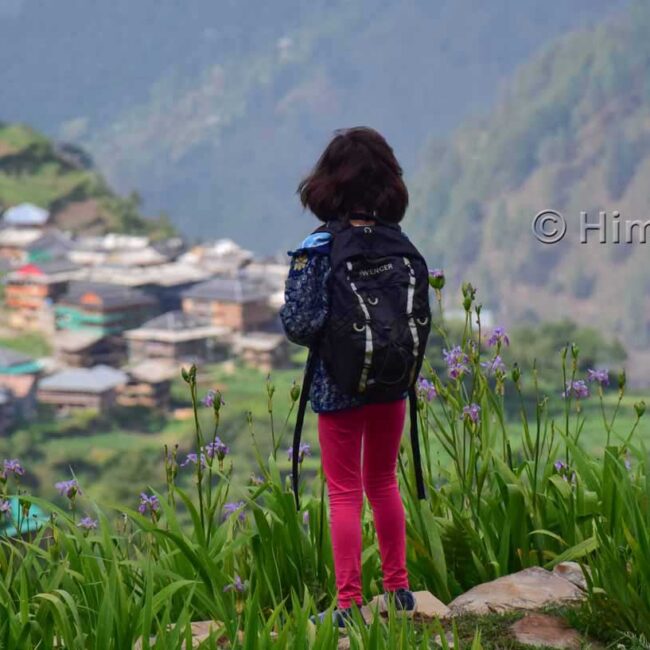 Un enfant regarde le village de Sarchi depuis le camping - camp d'été dans la vallée de Tirthan